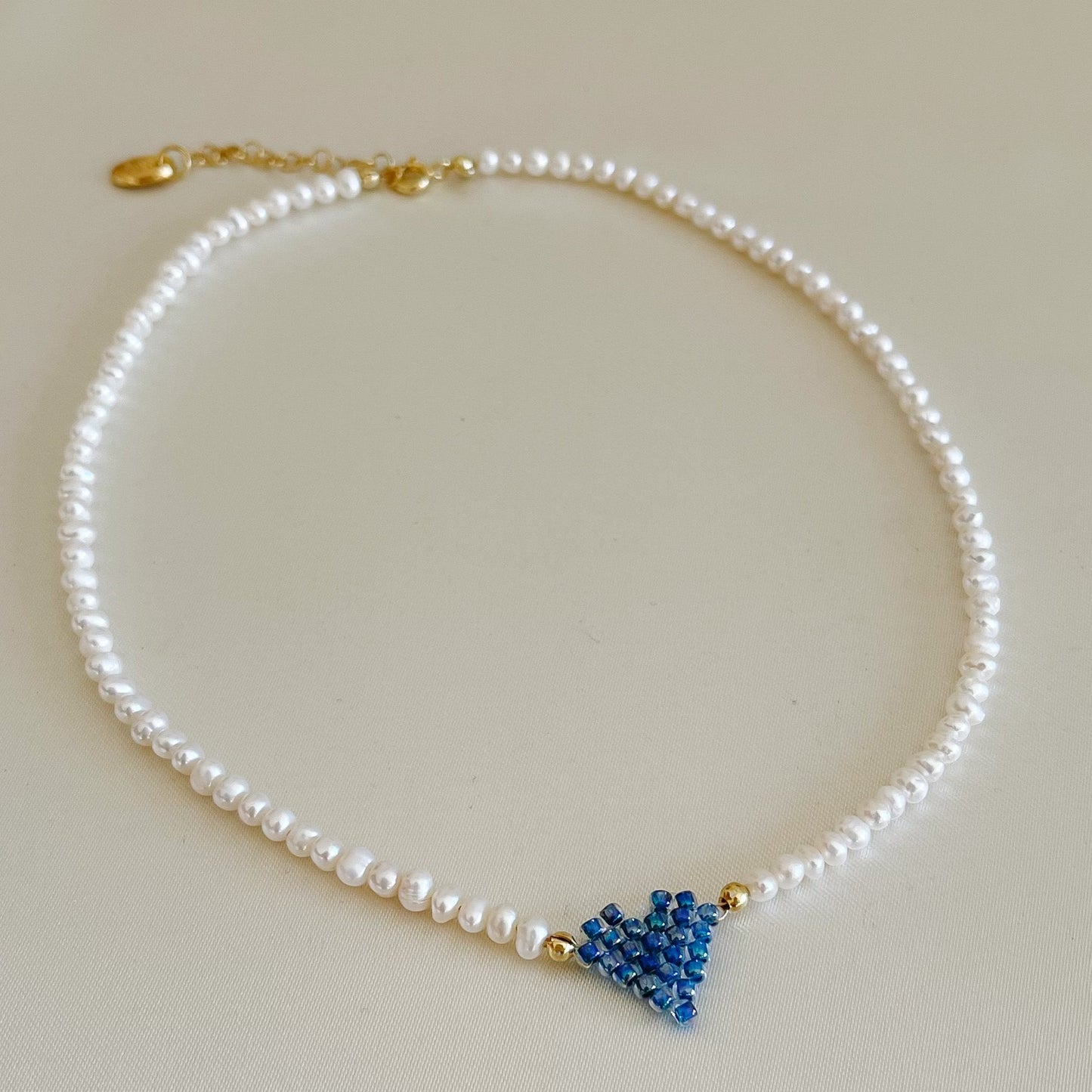 Collana di perle di fiume modello girocollo-coker  con in centro cuore in perline toho di colori diversi.  La collana CUORE nasce con lo scopo di celebrare l'amore.  MATERIALE: perle di fiume, perline toho, componenti e moschettone in argento 925 con galvanica color oro. DIMENSIONI: lunghezza collana: circa 39 cm + 4 cm catenella CUORE in perline di diversi colori a scelta: smeraldo-verde acqua-blu-vioa-pink- rosso scuro mat- rrosso-arancione mat-rosa baby-oro opaco mat