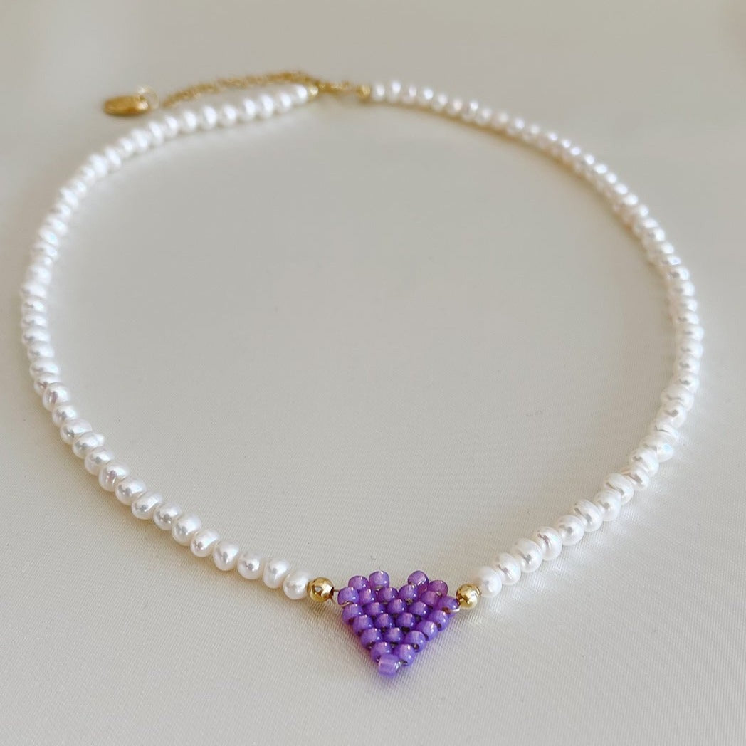 Collana di perle di fiume modello girocollo-coker  con in centro cuore in perline toho di colori diversi.  La collana CUORE nasce con lo scopo di celebrare l'amore.  MATERIALE: perle di fiume, perline toho, componenti e moschettone in argento 925 con galvanica color oro. DIMENSIONI: lunghezza collana: circa 39 cm + 4 cm catenella CUORE in perline di diversi colori a scelta: smeraldo-verde acqua-blu-vioa-pink- rosso scuro mat- rrosso-arancione mat-rosa baby-oro opaco mat