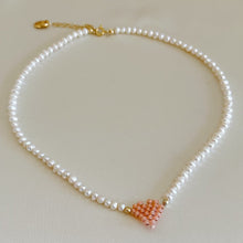 Carica l&#39;immagine nel visualizzatore di Gallery, Collana di perle di fiume modello girocollo-coker  con in centro cuore in perline toho di colori diversi.  La collana CUORE nasce con lo scopo di celebrare l&#39;amore.  MATERIALE: perle di fiume, perline toho, componenti e moschettone in argento 925 con galvanica color oro. DIMENSIONI: lunghezza collana: circa 39 cm + 4 cm catenella CUORE in perline di diversi colori a scelta: smeraldo-verde acqua-blu-vioa-pink- rosso scuro mat- rrosso-arancione mat-rosa baby-oro opaco mat