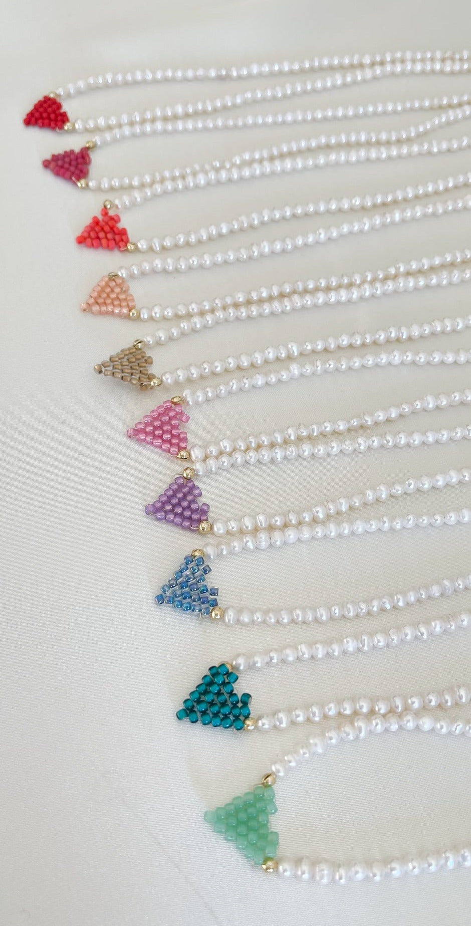 Collana di perle di fiume modello girocollo-coker  con in centro cuore in perline toho di colori diversi.  La collana CUORE nasce con lo scopo di celebrare l'amore.  MATERIALE: perle di fiume, perline toho, componenti e moschettone in argento 925 con galvanica color oro. DIMENSIONI: lunghezza collana: circa 39 cm + 4 cm catenella CUORE in perline di diversi colori a scelta: smeraldo-verde acqua-blu-vioa-pink- rosso scuro mat- rrosso-arancione mat-rosa baby-oro opaco mat